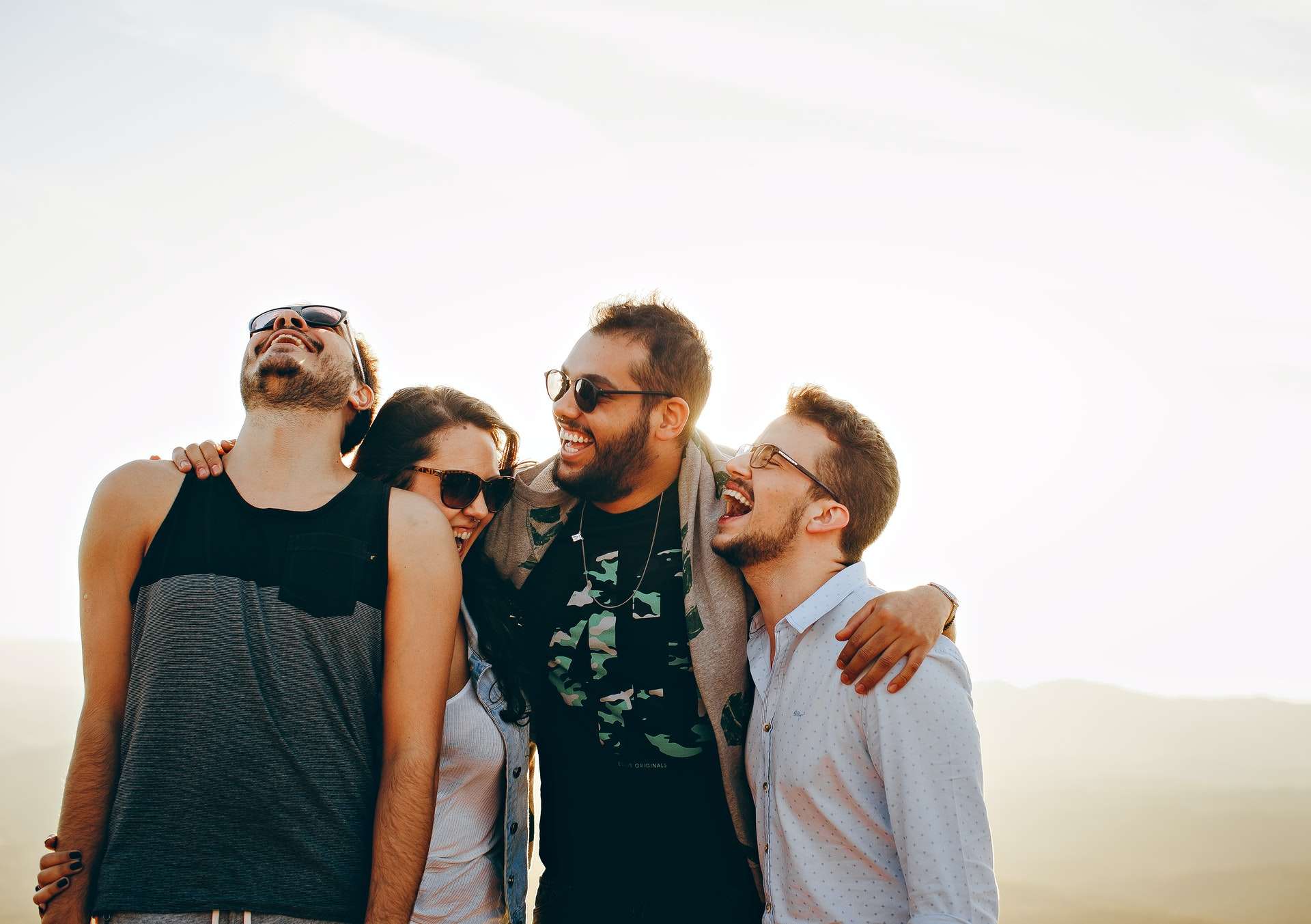 people laughing with their arms around each other