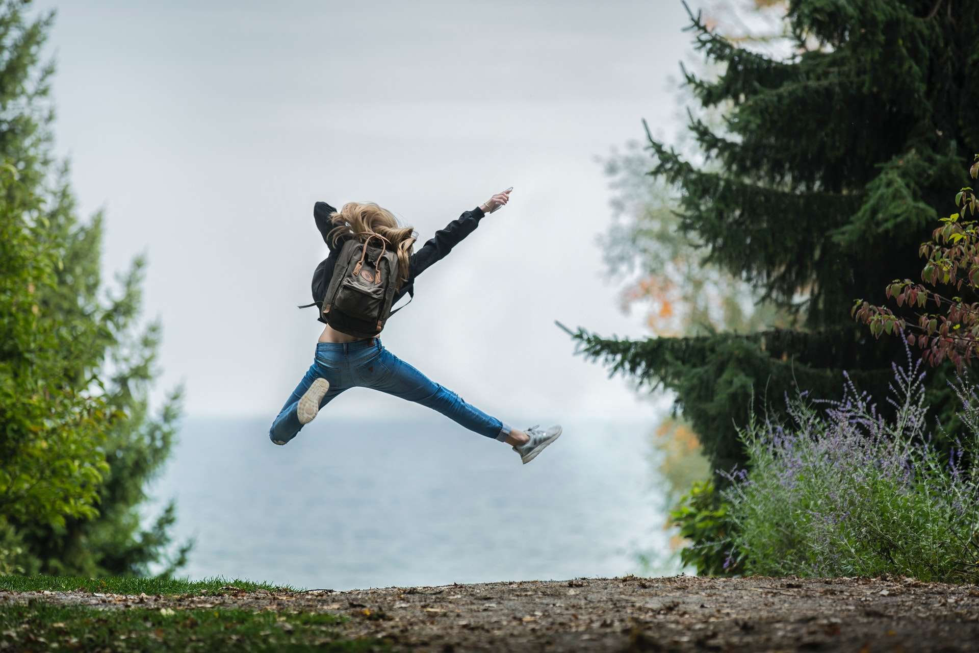 jumping woman with a backpack in the woods. Discover your God Given Destiny